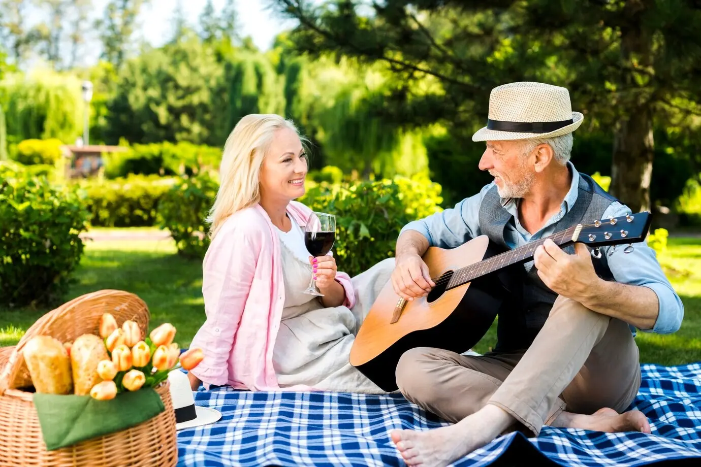 An elderly man playing the guitar for his lady.
